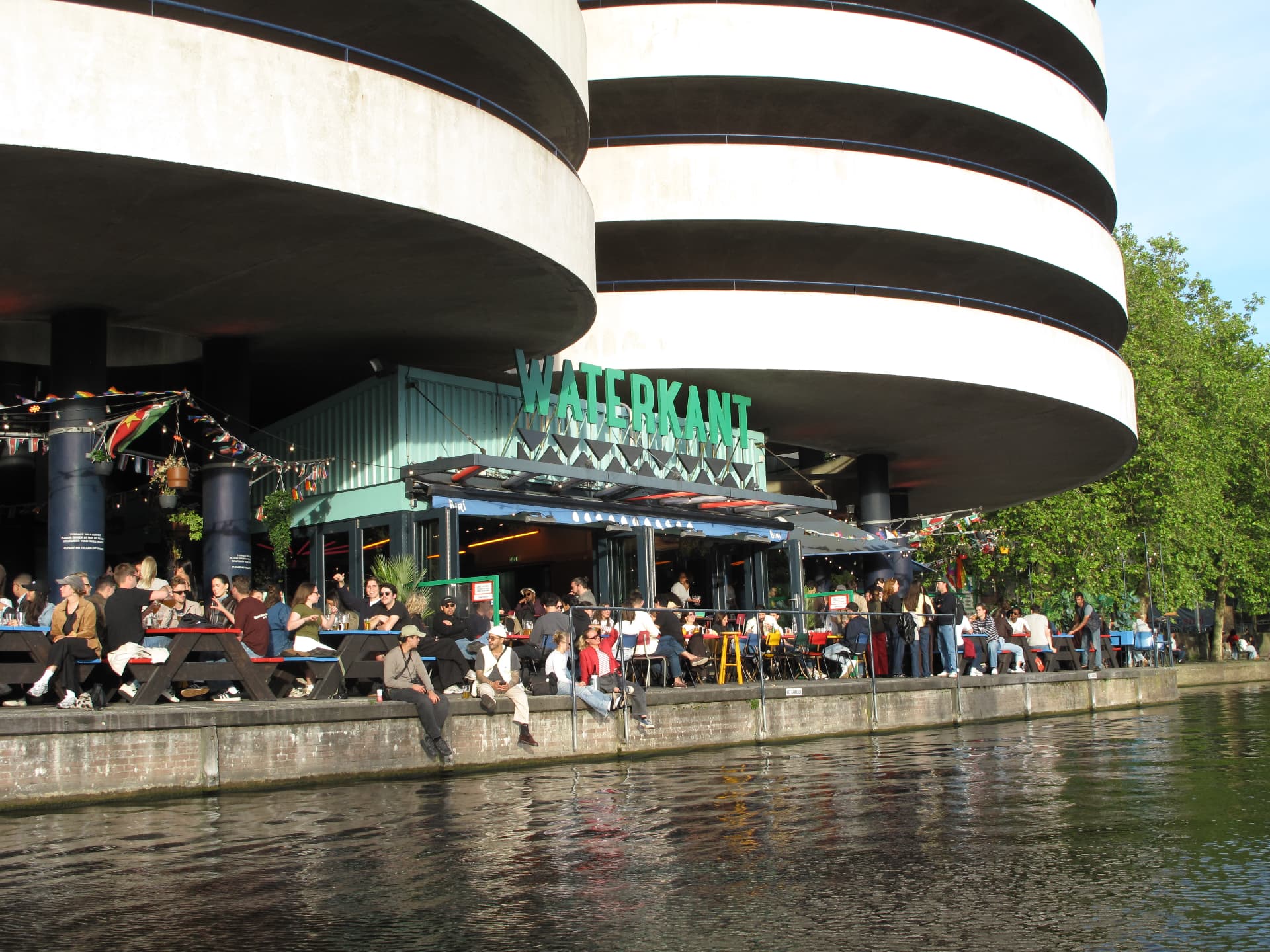 Waterkant terrace full of people right on the water