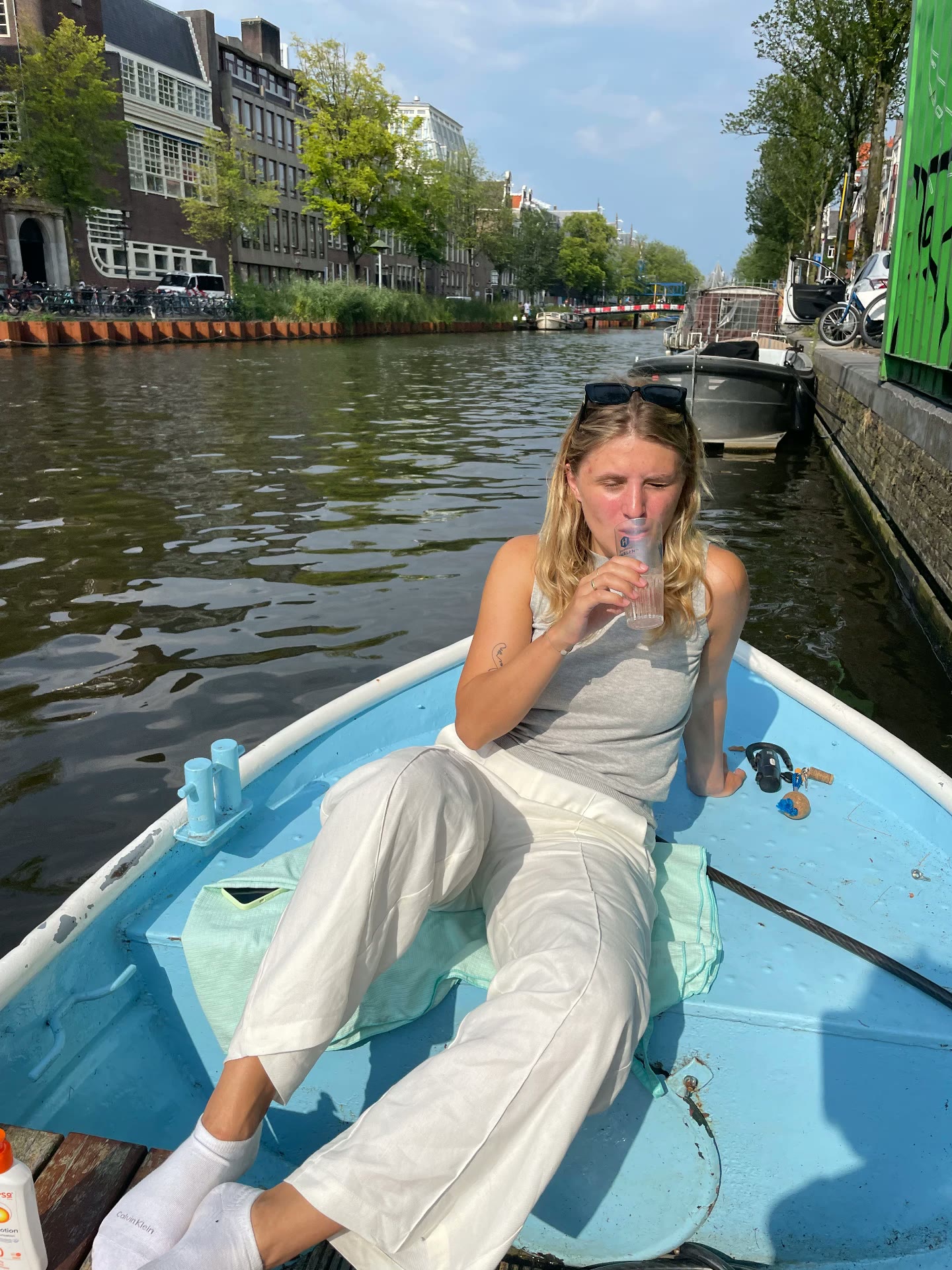 Lying in the bow of the boat with a drink on a hot day