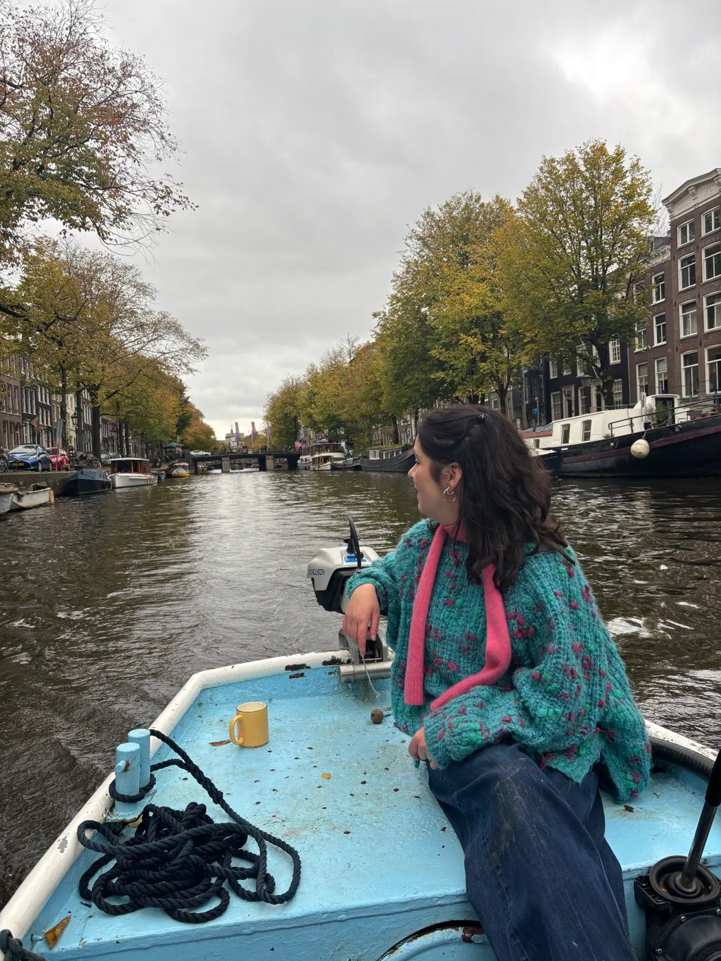 Steering the boat through the canal on a grey autumn day